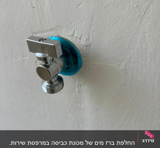 ברז מים מתכת על קיר לבן